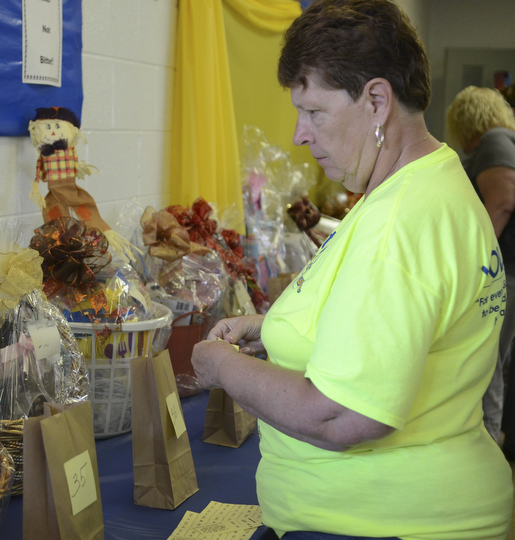 Jean Mancini of Youngstown looks at the basket raffle items and adds a ticket to the baskets of her choice at the Ukrainian Festival at St. Anne Ukrainian Church on Sunday, September 28, 2014 in Austintown.