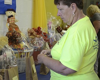 Jean Mancini of Youngstown looks at the basket raffle items and adds a ticket to the baskets of her choice at the Ukrainian Festival at St. Anne Ukrainian Church on Sunday, September 28, 2014 in Austintown.