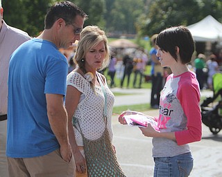 Mike Jeffery (left) and Tracey Ramun (middle ) of Canfield receive a pink ribbon, in honor of the upcoming breast cancer awareness month, from Kendra Meek of Youngstown State's Zeta Tau Alpha sorority during the Oktoberfest at the Boardman Park on Sunday afternoon. 