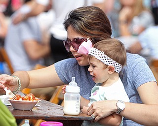Bailey Bowes (18 months) eats cavatelli while sitting on the lap of her mother, Bridget Bowes, both of Struthers during the Oktoberfest at the Boardman Park on Sunday afternoon.  Dustin Livesay  |  The Vindicator  09/28/14  Boardman Park.