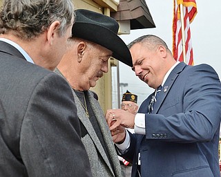 Jeff Lange | The Vindicator  Executive Director of the Trubmull County Veterans Service Commision, Herman Bruer (right) pins the Bronze Star to Vietnam War veteran Thomas Ducharme's jacket during the ceremony held at Texas Big Dog, Monday morning. In addition to the Bronze Star, Ducharme also received 9 other medals for his service in the Army.