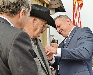 Vietnam War veteran Thomas Ducharme, center, receives the Bronze Star from Herman Breuer, right, executive director of the Trumbull County Veterans Service Commission. Looking on is U.S. Sen. Sherrod Brown, D-Ohio. Ducharme, who moved to Warren from Texas and opened a restaurant called Texas Big Dog, also received nine other medals Monday at the restaurant.