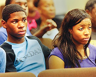 Jamon West, 14, and Sade Poindexter, 17, both of Youngstown, listen intently to advice from police about how to respond when picked up to avoid a confrontation.