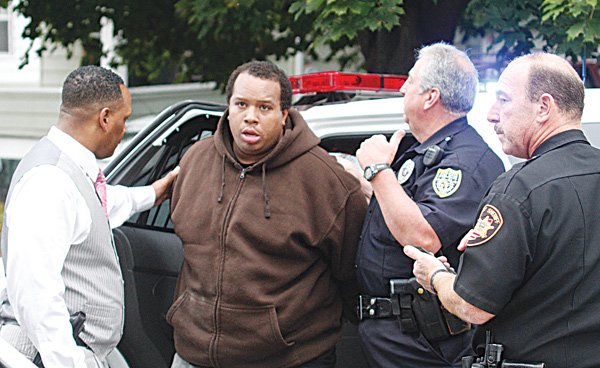 Willie Bright, center, is flanked by Youngstown police officers Carl Davis, left and Anthony Tulipano, and an unidentified Mahoning County Sheriff ’s deputy Wednesday as he was arrested at his South Side home after police say he pointed a gun at them.