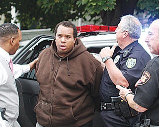 Willie Bright, center, is flanked by Youngstown police officers Carl Davis, left and Anthony Tulipano, and an unidentified Mahoning County Sheriff ’s deputy Wednesday as he was arrested at his South Side home after police say he pointed a gun at them.