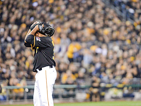 Pirates starting pitcher Edison Volquez grabs his head in disbelief after walking the Giants’ Brandon Belt in the second inning of the National League wildcard game Wednesday at PNC Park in Pittsburgh. The Giants routed the
Pirates, 8-0.