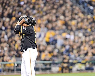 Pirates starting pitcher Edison Volquez grabs his head in disbelief after walking the Giants’ Brandon Belt in the second inning of the National League wildcard game Wednesday at PNC Park in Pittsburgh. The Giants routed the
Pirates, 8-0.