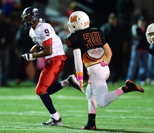 MASSILLON, OHIO - OCTOBER 3, 2014: Joey Harrington #9 of Fitch runs the ball away from John Henry Bronczek #30 of Massillon during the 1st half of Friday nights OHSAA football game at Massillon Washington High School. (Photo by David Dermer/Youngstown Vindicator)