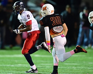 MASSILLON, OHIO - OCTOBER 3, 2014: Joey Harrington #9 of Fitch runs the ball away from John Henry Bronczek #30 of Massillon during the 1st half of Friday nights OHSAA football game at Massillon Washington High School. (Photo by David Dermer/Youngstown Vindicator)