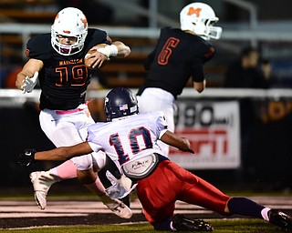 MASSILLON, OHIO - OCTOBER 3, 2014: JD Crabtree #19 of Massillon is tripped up in the backfield by Lawrence Harrington #10 of Fitch during the 1st half of Friday nights OHSAA football game at Massillon Washington High School. (Photo by David Dermer/Youngstown Vindicator)