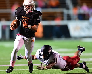 MASSILLON, OHIO - OCTOBER 3, 2014: Dylan Jackson #9 of Massillon runs the football before being tackled by a diving Tyler Hewlett #31 of Fitch during the 1st half of Friday nights OHSAA football game at Massillon Washington High School. (Photo by David Dermer/Youngstown Vindicator)