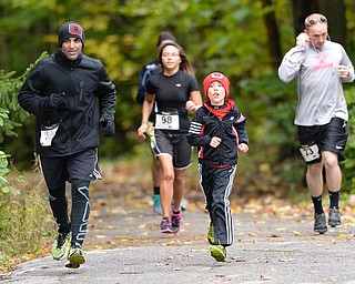 Jeff Lange | The Vindicator  Jentsen Barton, 9 years old of Canfield runs with family friend Satarp Manteghi (left) during Saturday morning's Hustle 4 Heart Reach 5K race held in Boardman.