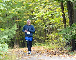 Jeff Lange | The Vindicator  Mimi Vass of Youngstown runs alone through the wooded portion of Saturday's Hustle for Heart Reach held in Boardman Park.