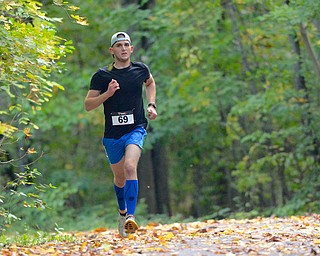 Jeff Lange | The Vindicator  Austintown's Anthony Costa emerges from the woods on the second lap of the Hustle 4 Heart Reach 5K race in Boardman. Costa went on to capture 1st place with a time of 18:50.6.