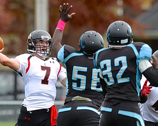 Jeff Lange | The Vindicator  Canfield quarterback Jake Cummings prepares to pass to a receiver over East's Artrell Ford (58) and Nick Ford (32) in the first half of Saturday's matchup at Rayen Stadium.