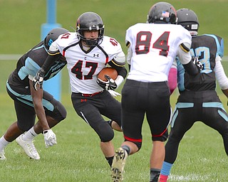 Jeff Lange | The Vindicator  CJ Frost of Canfield (47) rushes past East's TaBrian Donlow (back left) as he makes his way downfield, Saturday afternoon at Rayen Stadium.