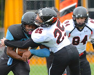 Jeff Lange | The Vindicator  East's Damon Green (left) collides with Canfield's Braxton Madison as he rushes for yards in the fourth quarter of the Panthers' matchup with the Canfield Cardinals, Saturday afternoon at Rayen Stadium.
