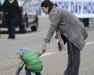 Katie Rickman | The Vindicator.Hayden Helm of Cresten, British Columbia reaches for candy on Wick Ave. as his mother Jasmine holds his hand during the 5th Annual Nonviolence Parade on Sunday, Oct. 5, 2014. A rally followed the parade which traveled from Wood St. in Youngstown, down Wick Ave. and ended at the Covelli Centre.