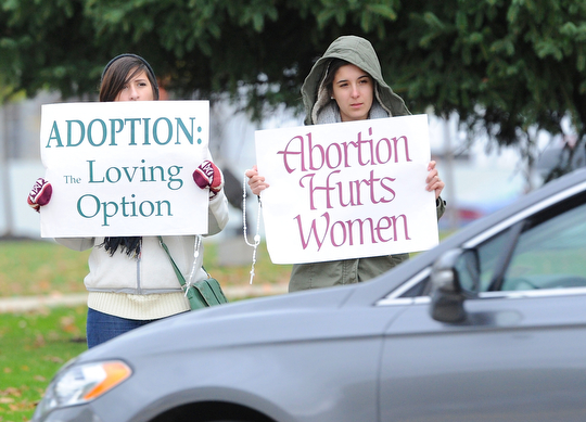 Jeff Lange | The Vindicator  Julia Bowman (left) and Maria Ruiz, members of St. Elizabeth Annseton Parish in Warren hold pro-life signs for drivers to see during Sunday's 24th annual Life Chain in the streets of Warren.