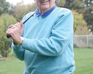 Joseph Skebo, a Korean War veteran, holds the club he used when he made a hole-in-one in the National Veterans TEE Tournament in Iowa City in September. Skebo, 83, of Boardman, is considered legally blind.