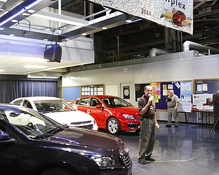        ROBERT K. YOSAY  | THE VINDICATOR..Tom Mock with the new 2015 red white and blue Cruzes with the 1 million sign ...GM is celebrating its 50th anniversary and they have invited us on the premises to celebrate and to see the 2015 Cruze...-30-