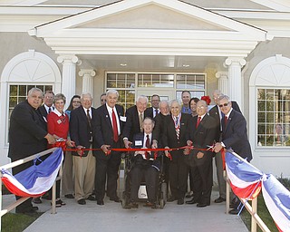        ROBERT K. YOSAY  | THE VINDICATOR..John M MacIntosh  front center in chair led the host of dignitaries as the Ribbon was cut..... The 6,000-square-foot, two-story building on Wick Avenue will house the YSU Office of Veterans Affairs and is designed to help improve and expand services to military veterans and service members transitioning to life as students at YSU....-30-