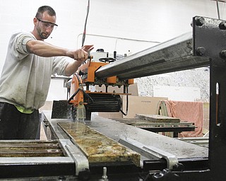 William D Lewis The Vindicator Your Tile Center employee Travis Marriotti cuts a piece of granite.