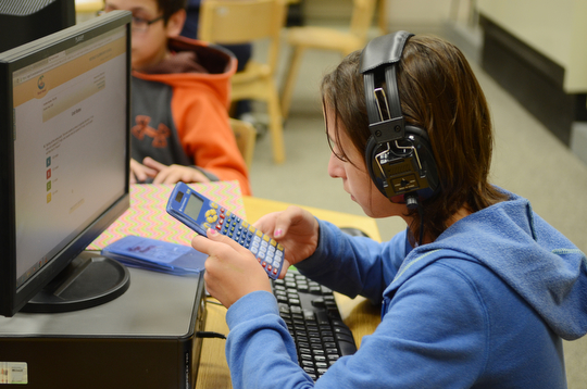 Katie Rickman | The Vindicator.Kyle Posey, a sixth grader at Poland McKinley Elementary School uses her calculator while doing math problems on a computer in the library at the school on Monday, October 6, 2014.  Poland Elementary School students use computers to do math and language arts homework and tests.