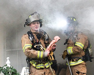 Canfield firefighter Tim Frease, above, carries a baby doll from a home filled with fake smoke during a training
exercise Monday in Canfield. Firefighters practiced search and rescue.