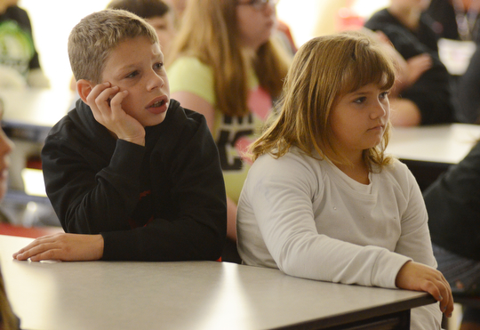 Katie Rickman | The Vindicator.Ryan Donnadio, on left, and Gracey Greenwalt, both 3rd grade students at Struthers Elementary School listen watch a movie on fire safety at the school on Tuesday, Oct. 7, 2014. Struthers Fire Department hosted the even where students watched a short film about fire safety and ended with a questions and answers session from the students.