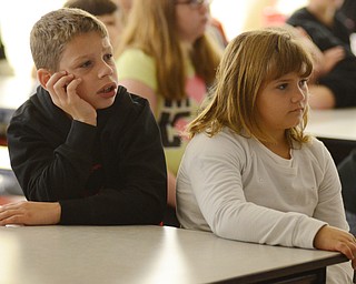 Katie Rickman | The Vindicator.Ryan Donnadio, on left, and Gracey Greenwalt, both 3rd grade students at Struthers Elementary School listen watch a movie on fire safety at the school on Tuesday, Oct. 7, 2014. Struthers Fire Department hosted the even where students watched a short film about fire safety and ended with a questions and answers session from the students.