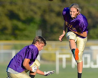 Jeff Lange | The Vindicator  Kayle Hubbs, freshman at Sebring kicks the ball through uprights from the hand of Brett Weekly, senior at Sebring, Monday afternoon during football practice.