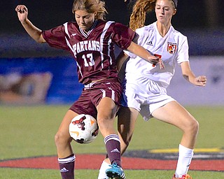 Jeff Lange | The Vindicator  Spartans' Alison Green (left) and Canfield's Paije Georgeoff fight for the ball during first half play at Bob Dove Field, Monday night.