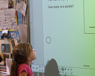        ROBERT K. YOSAY  | THE VINDICATOR..South Range Schools with Superintendent .Dennis Dunham.. has used a varitey of new educational tools to increase learning and decrease costs saving over 70000 dollars.....Chloe Kane a first grader solves a problem on a smart board .-30-