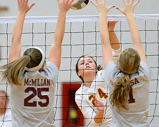 Jeff Lange | The Vindicator  Mooney's McKenzie Reese spikes the ball into the face of Boardman's Amber McMillan (left) and Rachel Hosa (right) during their matchup at Mooney, Wednesday night.