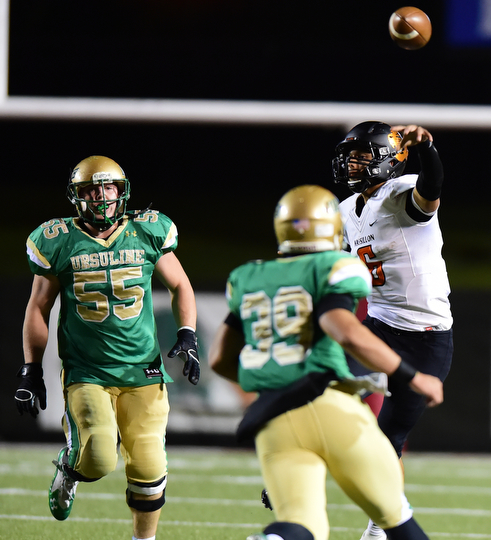 YOUNGSTOWN, OHIO - OCTOBER 10, 2014: Danny Clark #6 of Massillon throws a pass while avoiding the pass rush from Vito Penza #39 and Giacamo Cappabianca #55 of Ursuline during the 1st half of Friday nights OHSAA game at Stambaugh Stadium. (Photo by David Dermer/Youngstown Vindicator)