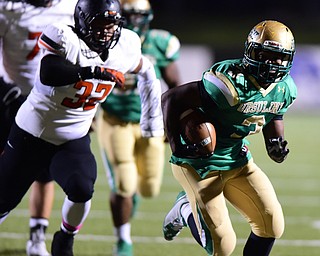 YOUNGSTOWN, OHIO - OCTOBER 10, 2014: Kimauni Johnson #3 of Ursuline runs the football away from Austin Dixon #32 of Massillon during the 1st half of Friday nights OHSAA game at Stambaugh Stadium. (Photo by David Dermer/Youngstown Vindicator)