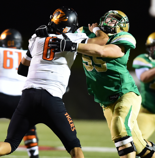 YOUNGSTOWN, OHIO - OCTOBER 10, 2014: Danny Clark #6 of Massillon attempts to avoid being brought down by Giacamo Cappabianca #55 of Ursuline during the 1st half of Friday nights OHSAA game at Stambaugh Stadium. (Photo by David Dermer/Youngstown Vindicator)