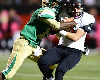 YOUNGSTOWN, OHIO - OCTOBER 10, 2014: Dylan Henderson #9 of Massillon is tackled by Marcus Mosley #11 of Ursuline after a reception during the 1st half of Friday nights OHSAA game at Stambaugh Stadium. (Photo by David Dermer/Youngstown Vindicator)
