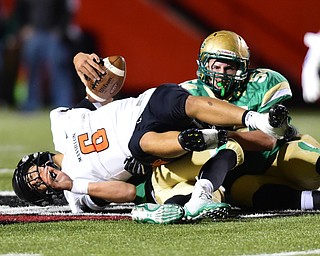 YOUNGSTOWN, OHIO - OCTOBER 10, 2014: Danny Clark #6 of Massillon is sacked in the backfield by Jabbar Price #52 and Tyler Leonard #54 of Ursuline during the 1st half of Friday nights OHSAA game at Stambaugh Stadium. (Photo by David Dermer/Youngstown Vindicator)
