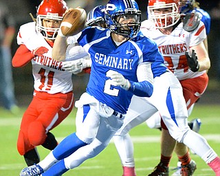 Jeff Lange | The Vindicator  Quarterback Dom Petrony (2) of Poland rushes for yards away from Struthers' Jalen Trimacco (left) and Jay King (right) in the second quarter of Friday night's game at Dave Pavlansky Field.