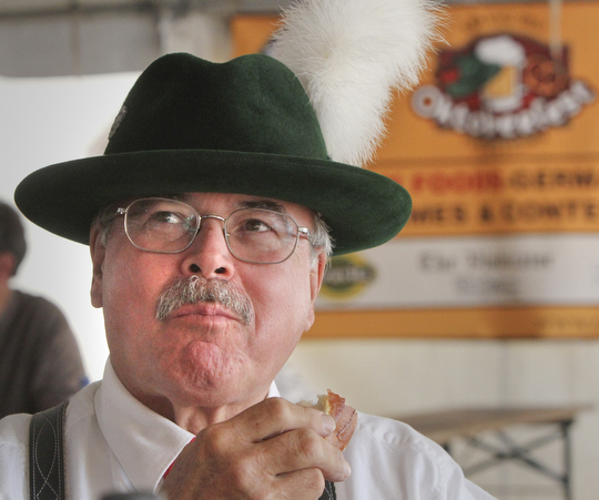William D Lewis the vindicator Tom Englert, member of Alpen Schuhplatter Dancers of Pittsburgh enjoys a German pretzel during Oktoberfest Youngstown at Kravitz Deli in Liberty Sunday.