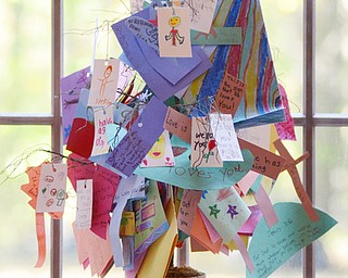 Katie Rickman | The Vindicator.Notes from children at Heartland Christian School hang from a small version of the Luvya Tree in the living room of D’Wayne Robinson’s Canfield home on Thursday, Oct. 9, 2014. D’Wayne discusses the book that he wrote called The Luvya Tree which discussed the illness of his wife and her death.