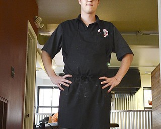 Katie Rickman | The Vindicator.Ross Fowler poses under the sign for his new business "The Kitchen Post" which is located in Friends Specialty downtown Youngstown on Thursday, Oct. 9, 2014.