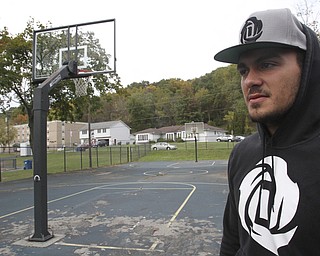 William D. Lewis The Vindicator  Dom DeFrank, 19, of Lowellville, stands on basketball court. He won an online contest to help fund restoration of the courts.