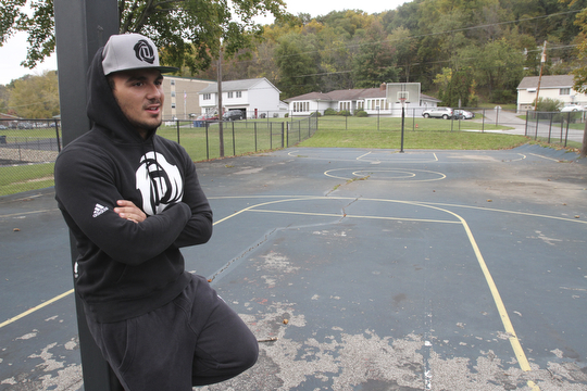William D. Lewis The Vindicator  Dom DeFrank, 19, of Lowellville, stands on basketball court. He won an online contest to help fund restoration of the courts.