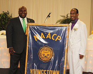 Steven Mickel (right) of the NAACP Youngstown chapter stands with Sammie Dow , National Youth and College Director of the NAACP, next to the NAACP Youngstown Chapter banner during the NAACP banquit at the Mahoning Country Club in Liberty on Friday evening.  Dustin Livesay  |  The Vindicator  10/10/14  Mahoning Country Club