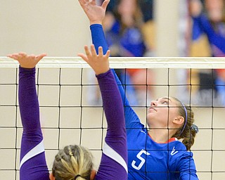 Jeff Lange | The Vindicator  Western Reserve's Rachel Maslach (5) spikes the ball over the net as Sebring's Mady Kreitzer reaches up to defend, Thursday night at Western Reserve High School. Maslach reached a milestone of having over 1,000 assists.