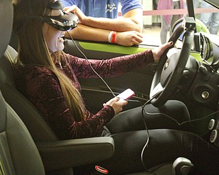        ROBERT K. YOSAY  | THE VINDICATOR..laughing as she crashes...   Nya Beconder (ok).. is behind the chevy State Farm brought in a car courtesy of Sweeney Chevrolet -  to Boardman  high school so that students can do demos of different driving scenarios. Supposed to teach driving safety, such as not to text and drive. etc.....-30-