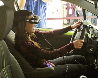        ROBERT K. YOSAY  | THE VINDICATOR..laughing as she crashes...  Nya Beconder (ok)... is behind the chevy State Farm brought in a car courtesy of Sweeney Chevrolet -  to Boardman  high school so that students can do demos of different driving scenarios. Supposed to teach driving safety, such as not to text and drive. etc.....-30-